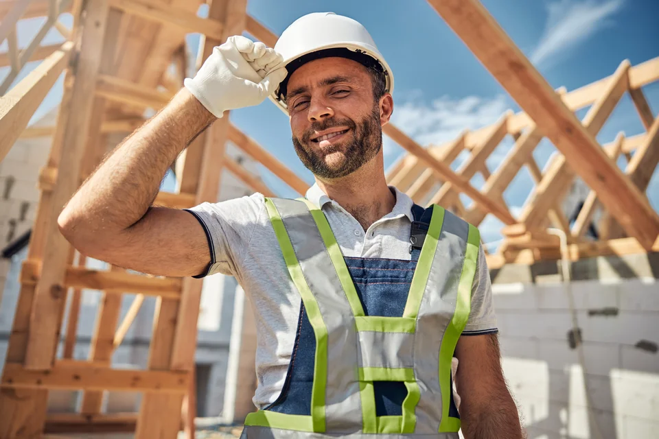 Trabajador con casco frente a una estructura de madera